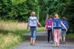 Schulranzen, 4 Kinder auf Kies...